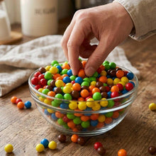 Load image into Gallery viewer, A clear glass bowl filled with sixlets candy 
