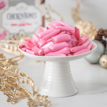 Load image into Gallery viewer, Pink Chicken Bones on a white pedestal dish with decorative elements in the background